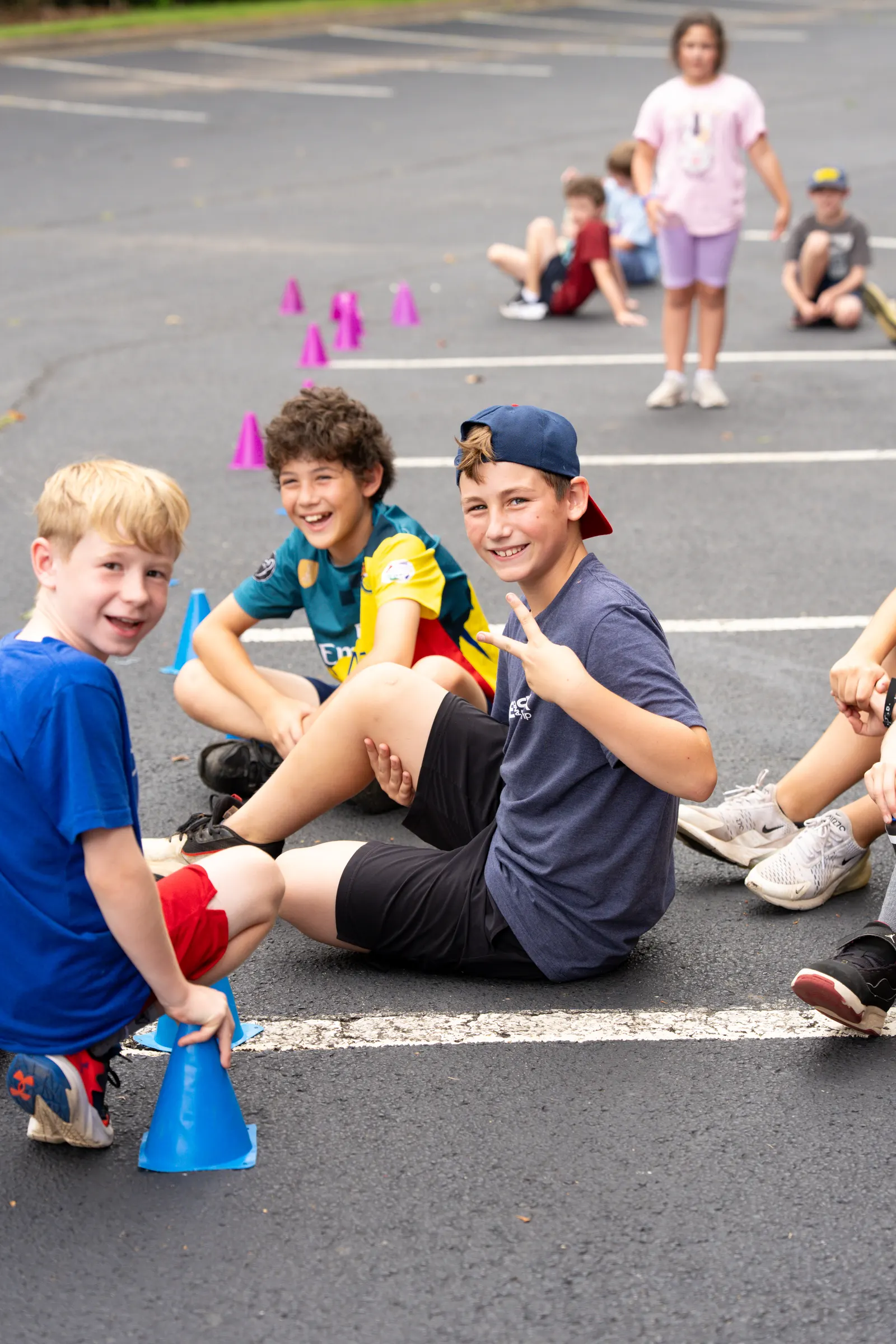 Counselor and campers sitting on the pavement