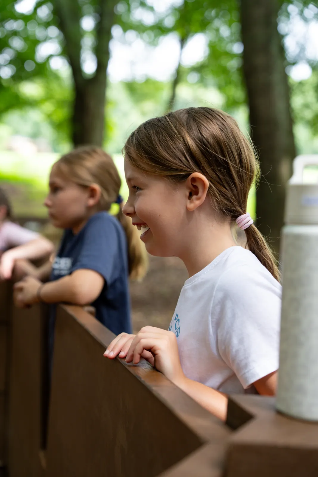 Two campers looking over a wooden rail