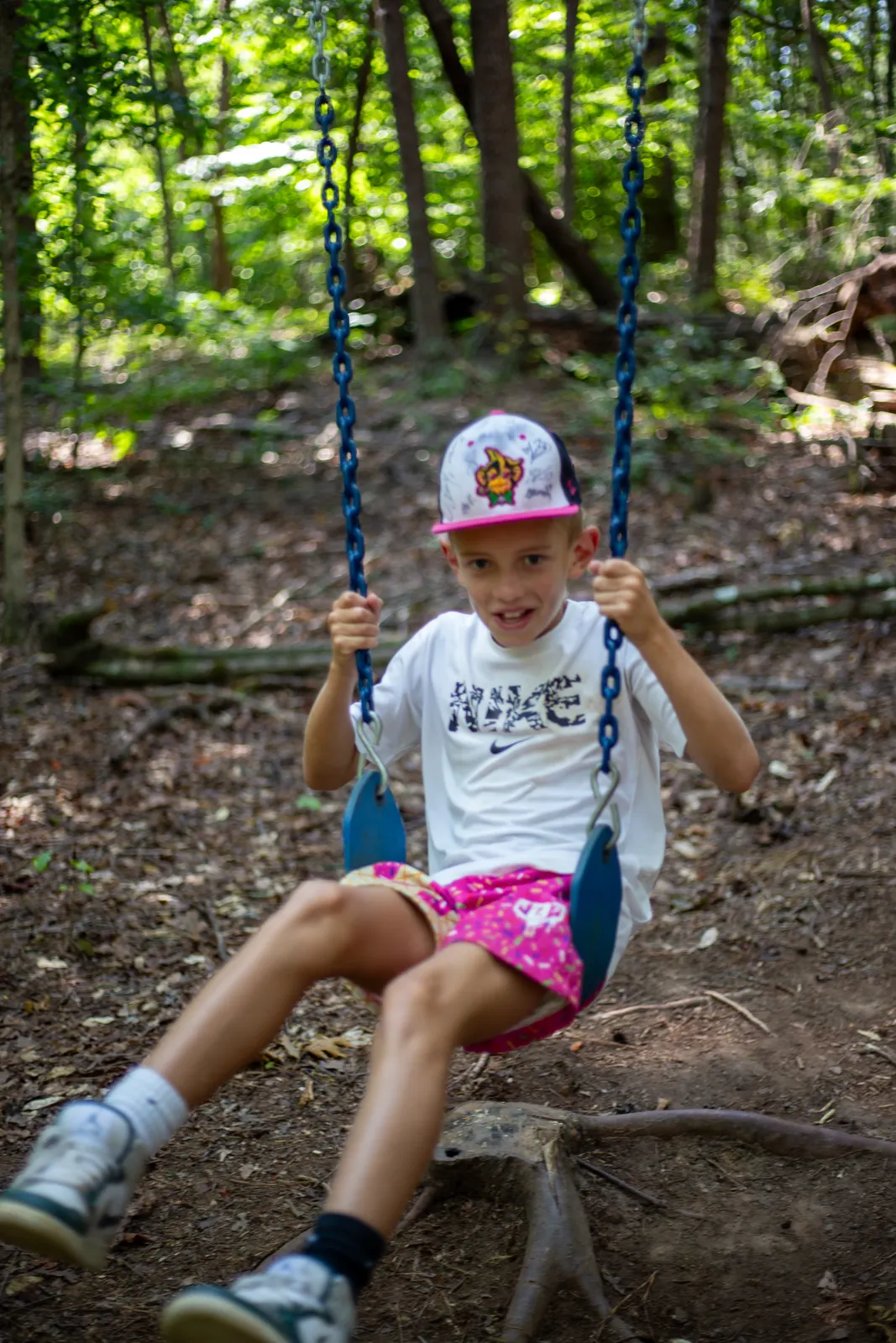 Camper on a rope swing in the woods