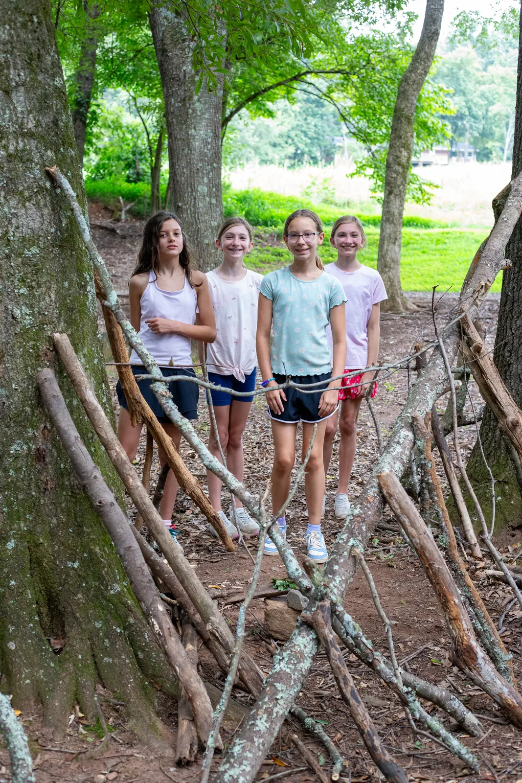 Campers standing on a stick fort in the woods