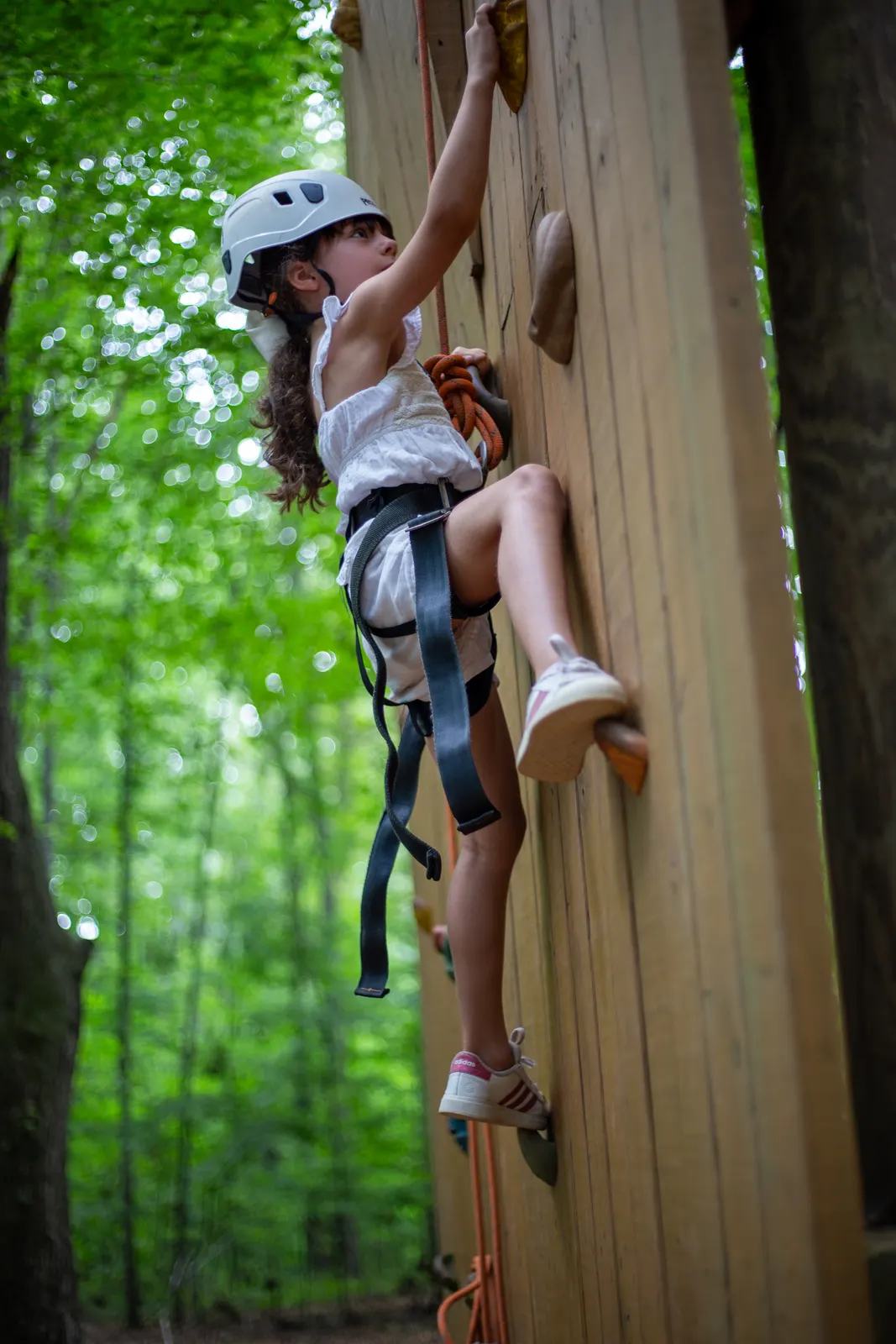 Camper in a helmet on the climbing wall