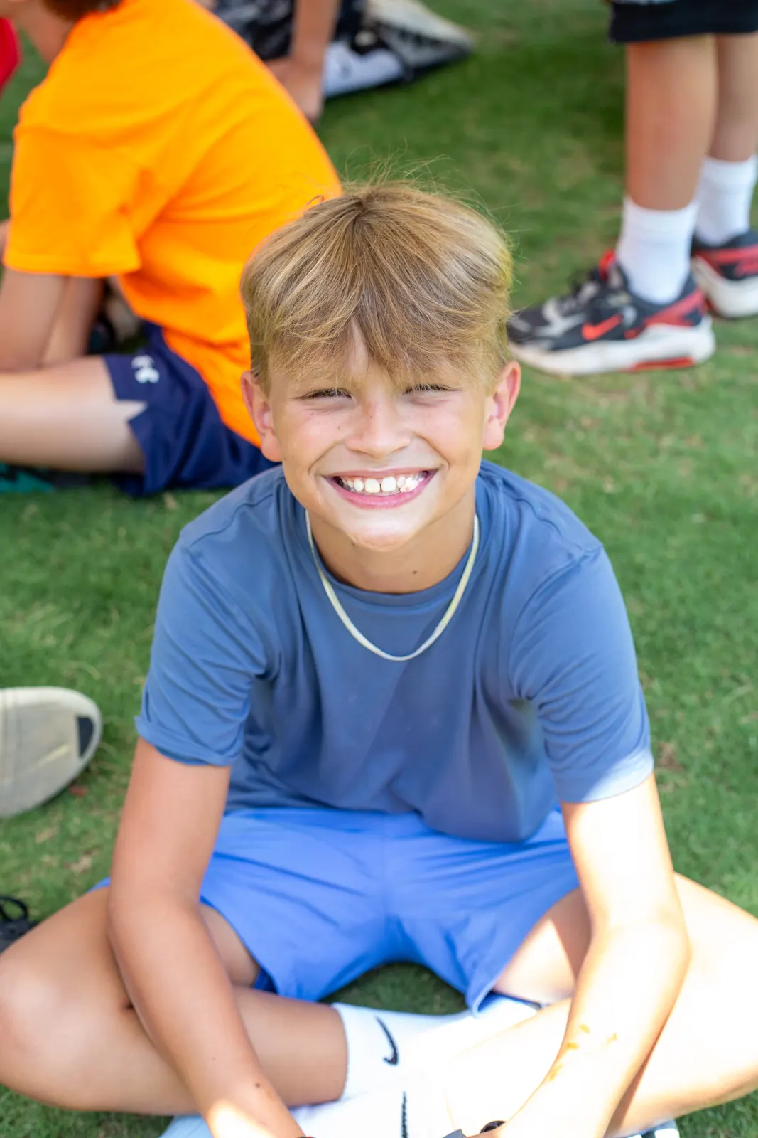 Camper sitting on the grass smiling