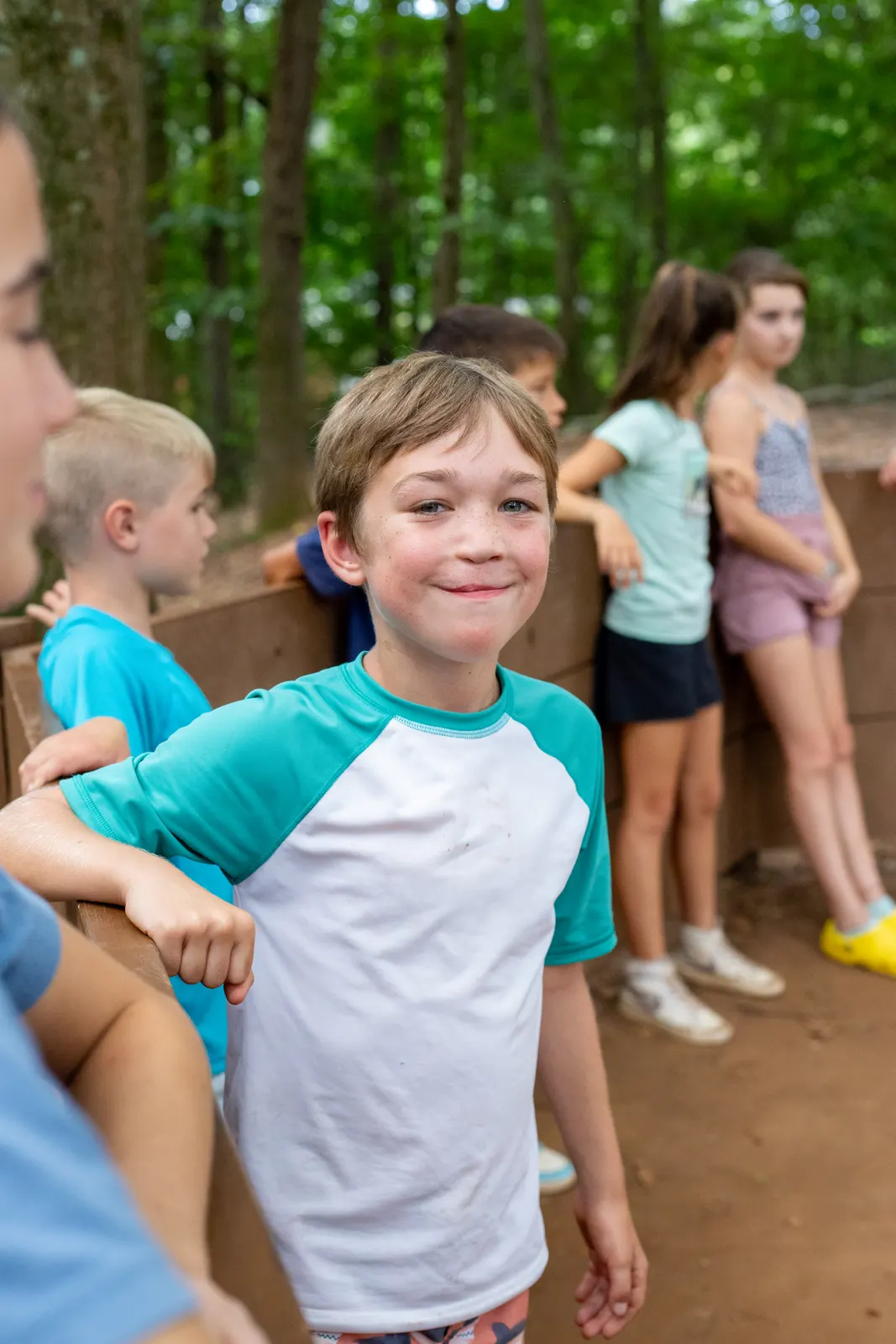 Camper smiling with friends in the woods