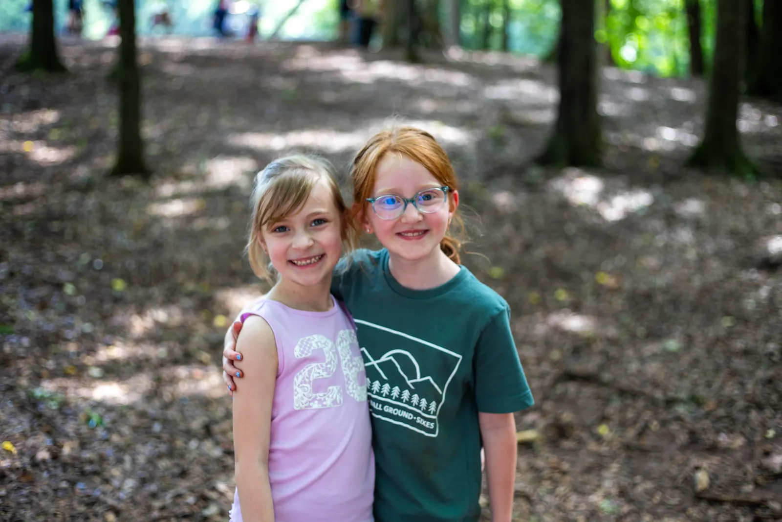 Two campers smiling in the woods